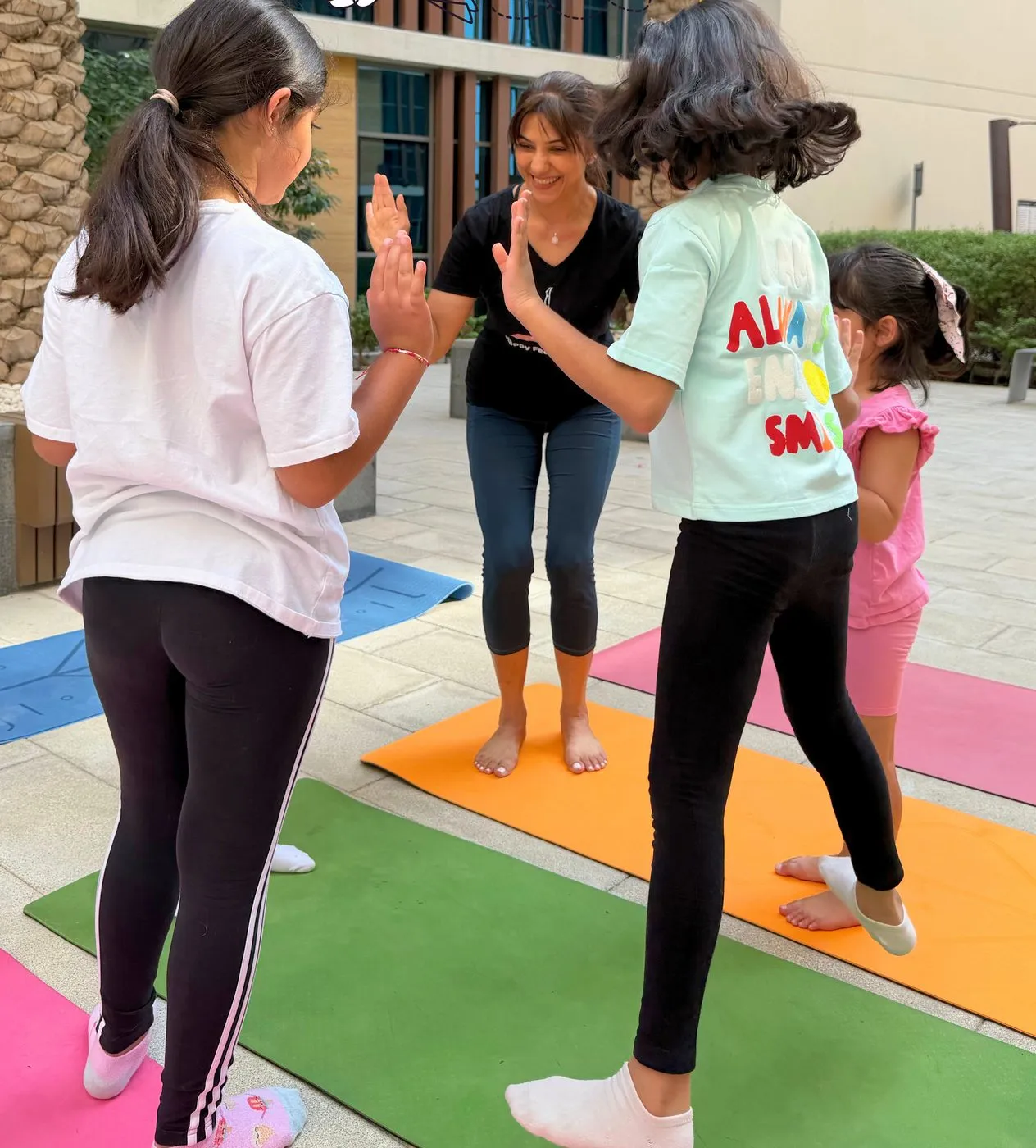 An outdoor kids class on the grass, children copying a pose